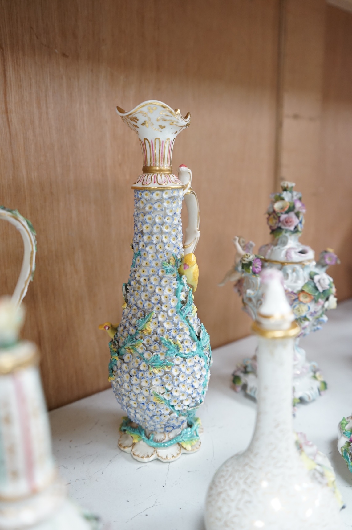 A group of English porcelain flower encrusted scent bottles and yours, Coalport, Minton etc., c.1830-50 together with Continental porcelain figures a wall pocket etc, largest 26cm high